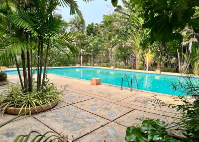 Spacious outdoor pool surrounded by lush greenery in a luxurious residential property