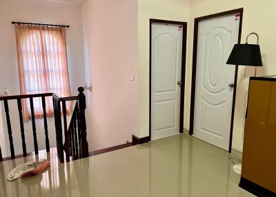 Bright and spacious upper floor hallway with two doors and a balcony view