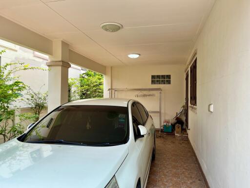 Spacious covered garage with a parked car and storage space