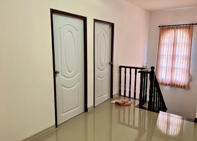 Spacious, bright hallway with polished tiles and multiple doors