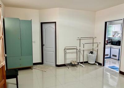 Spacious bedroom with wardrobe, door, and partial view of the kitchen