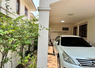 Well-maintained home exterior with a parked car and lush greenery