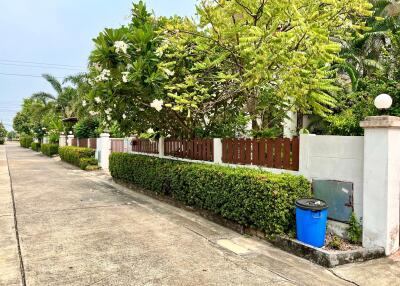 Lush greenery and tidy suburban street with private fencing
