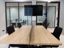 Modern office meeting room with large wooden table and ergonomic chairs