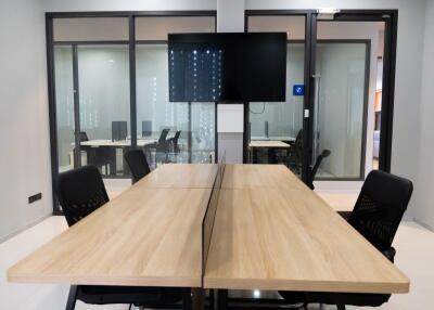 Modern office meeting room with large wooden table and ergonomic chairs