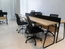Spacious office room with large wooden table and chairs