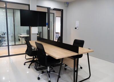 Modern office space with large wooden desk and ergonomic chairs