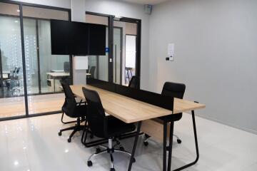 Modern office space with large wooden desk and ergonomic chairs