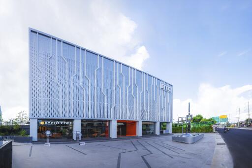 Modern commercial building with distinctive patterned facade and integrated cafe