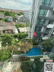 Aerial view of a modern residential complex with pool and lush greenery