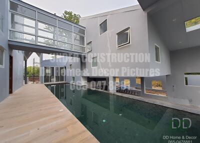 Modern home exterior with swimming pool and connecting bridge