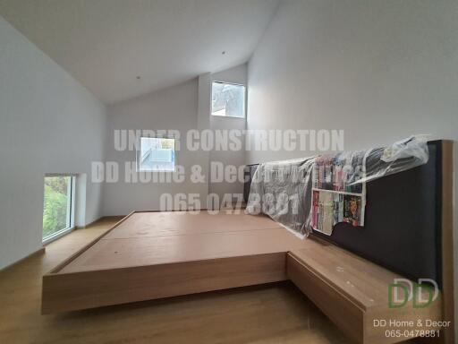 Spacious bedroom under construction with large windows and wooden flooring