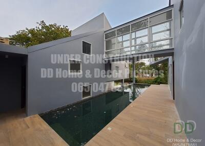 Modern house exterior under construction with glass facade and swimming pool