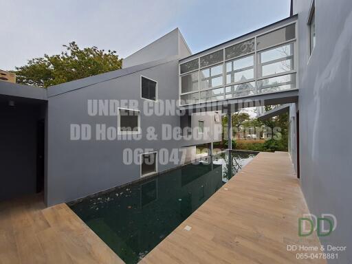 Modern house exterior under construction with glass facade and swimming pool