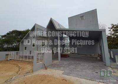 Contemporary house under construction with visible structural details and exterior design