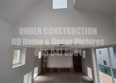 Spacious under construction living room with high ceilings and large windows