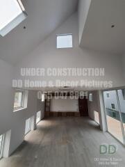 Spacious under construction living room with high ceilings and large windows