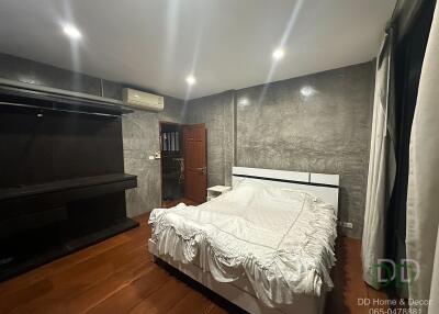 Modern bedroom with white bed and wooden flooring