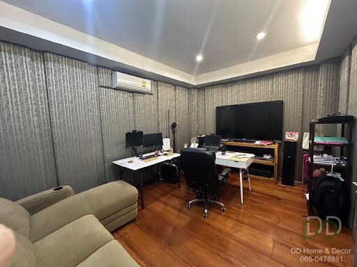 Spacious home office with desks, chairs, and monitors