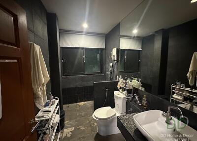 Modern bathroom with dark tiles and large mirror