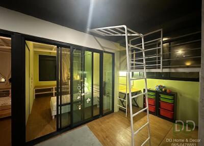 A modern bedroom with a loft bed and glass sliding doors