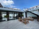 Spacious rooftop terrace with comfortable seating and modern design under a clear blue sky