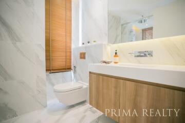 Modern bathroom with marble tiles and wooden vanity