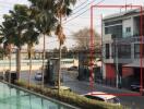 Modern urban building with foreground pool and lush palm trees