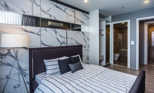 Modern bedroom with elegant marble wall design and stylish furnishings