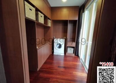 Spacious storage room with built-in wooden cabinets and washing machine