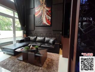 Spacious living room with modern leather sofa and artistic decor