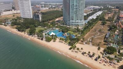 Aerial view of luxury residential towers near the beach with pool and lush gardens