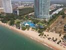 Aerial view of luxury residential towers near the beach with pool and lush gardens