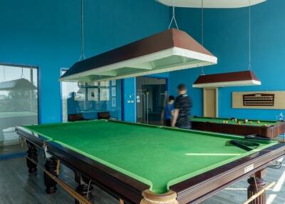 Spacious game room with a large billiard table and striking blue walls