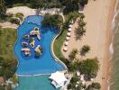 Aerial view of a luxurious outdoor swimming pool by the beach