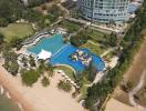 Aerial view of a luxurious resort with pool and beachfront