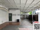 Spacious covered parking or multipurpose area with metal roof and tiled floor