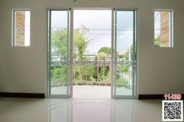 Bright and spacious living room with large glass doors opening to a balcony