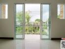 Bright and spacious living room with large glass doors opening to a balcony