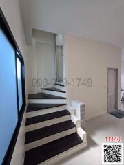 Modern staircase in a residential house with large window and neutral color scheme