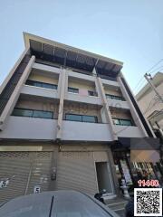 Modern multi-story commercial building facade with shuttered storefronts