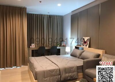 Modern bedroom with integrated living area, featuring stylish furniture and warm lighting