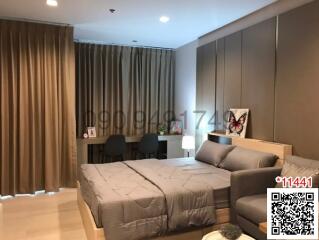 Modern bedroom with integrated living area, featuring stylish furniture and warm lighting