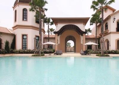 Luxurious pool area with a grand building in the background featuring Mediterranean architecture