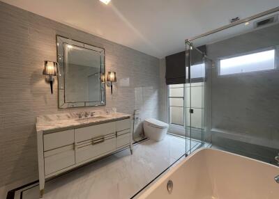 Spacious modern bathroom with large bathtub and glass shower