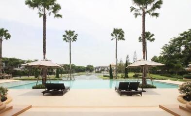 Luxurious resort-style pool area with sun loungers and umbrellas