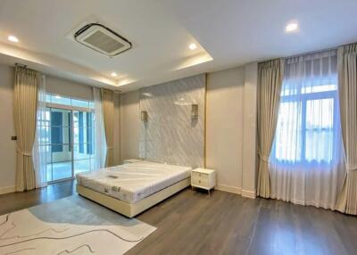 Spacious bedroom with large bed, modern design, and balcony access