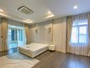 Spacious bedroom with large bed, modern design, and balcony access