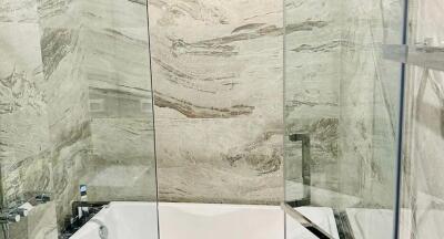 Modern bathroom with luxurious marble walls and glass shower enclosure