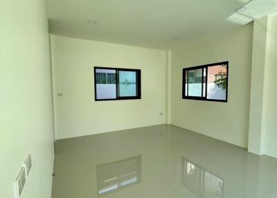 Spacious and bright empty living room with glossy tiled flooring and large windows